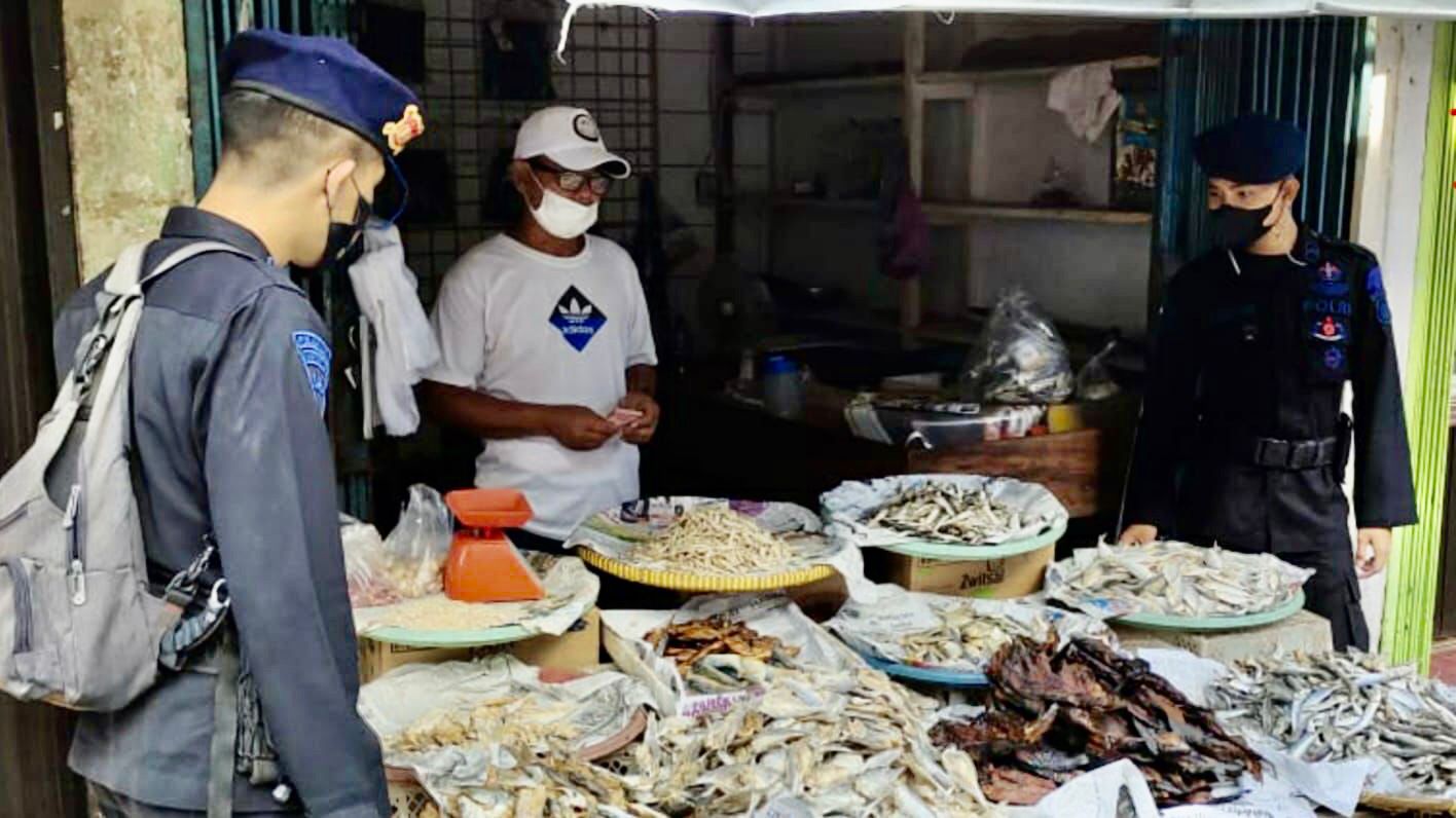 Personel Brimob Sumsel Ingatkan Masyarakat Untuk Patuhi Prokes Saat Menyambangi Pasar Bhayangkara Pali